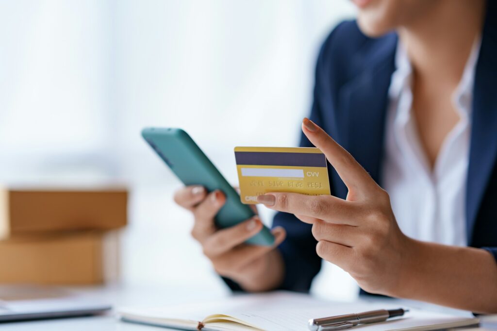 Young woman using a credit card through a smartphone application for online shopping and online paym